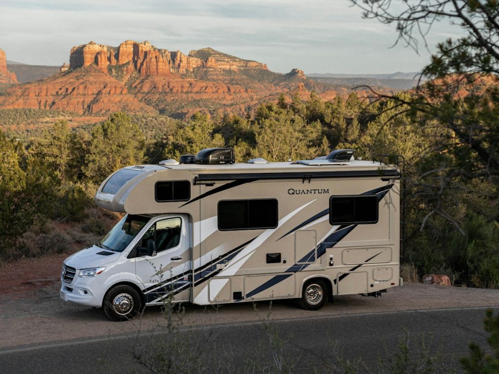 Motorhome below desert cliffs